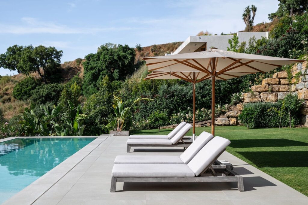 Villa Sesa: designvilla met infinity pool en zeezicht in Benahavís 3 Ligbedden aan het zwembad tussen het groen