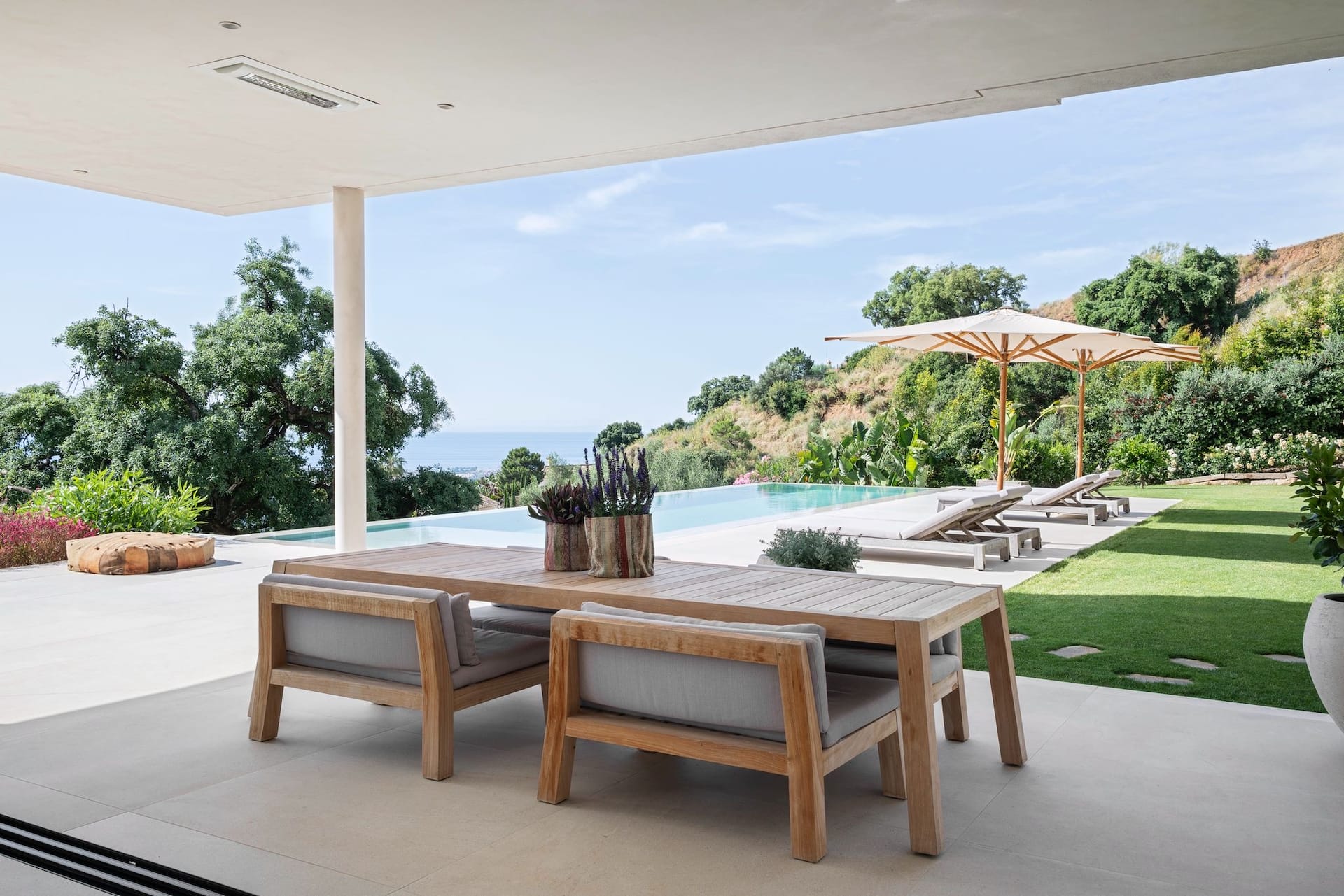 Villa Sesa: designvilla met infinity pool en zeezicht in Benahavís 18 Overdekte eettafel buiten met zicht op het zwembad